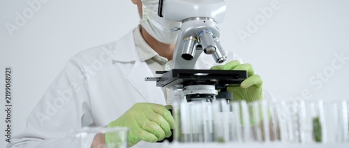 Obraz na płótnie Scientist wearing a face mask, safety goggles, and protective gloves, precisely