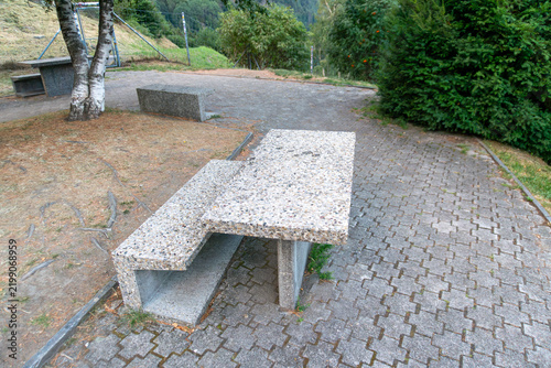 Cuadro en lienzo Heavy exposed aggregate concrete picnic table with matching benches stands on a paved outdoor recreation area