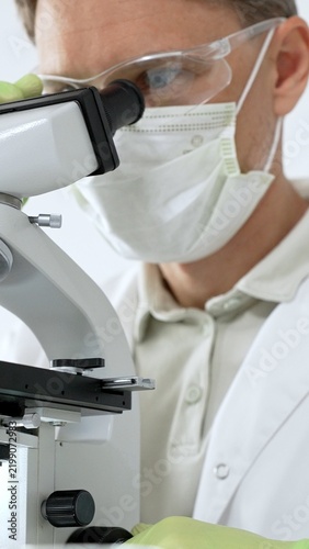 Obraz na płótnie Scientist working with microscope, analyzing biological samples in a research la