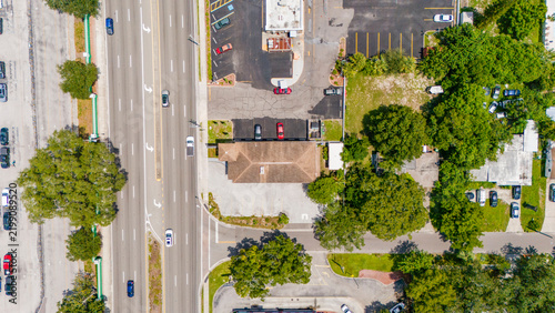 Canvas Print Vertical aerial view looking down at a busy multi-lane highway and adjacent park