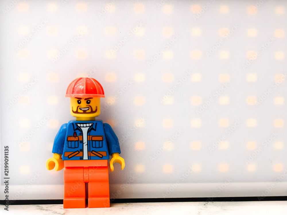 Fototapeta premium Russia, St. Petersburg, August 8, 2020 A close-up of a Lego man wearing a hard hat, great for illustration or construction-themed designs