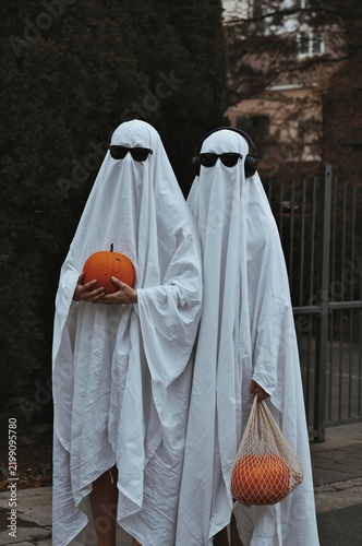 People Dressed as Ghosts With Pumpkins in a Neighborhood During Halloween