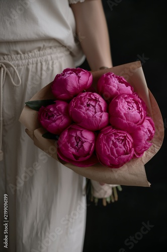 Bright Pink Peonies Held in a Hand With a Simple Paper Wrap