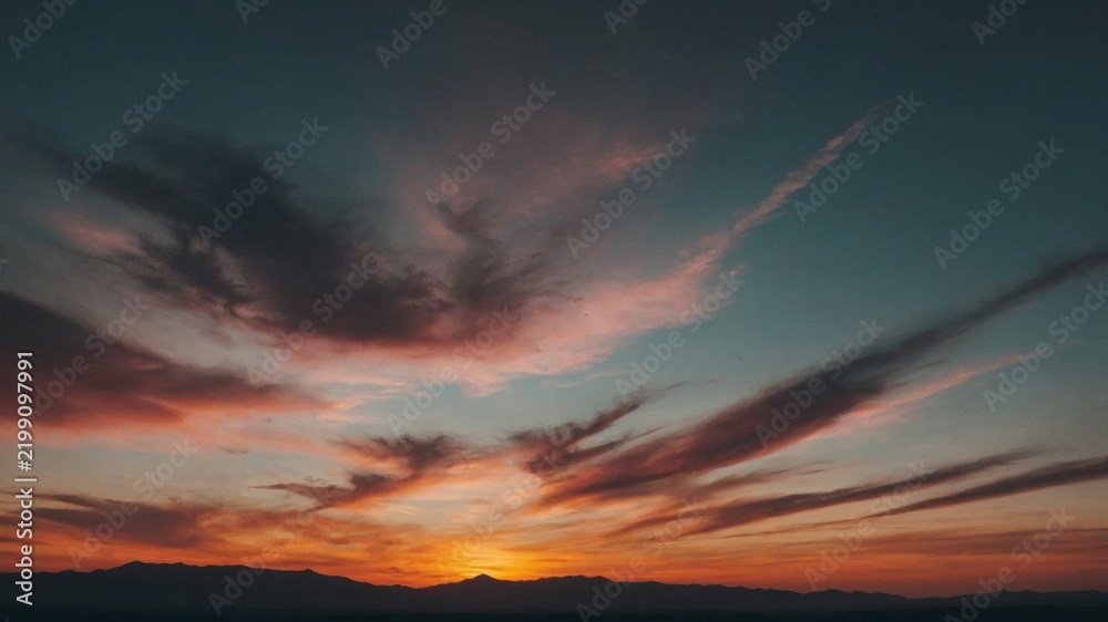 Fototapeta premium Sunset Over Mountains With Colorful Clouds in the Sky