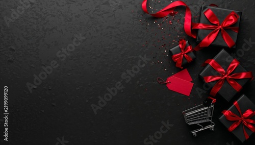 Gifts Arranged With Ribbons and a Shopping Cart on a Black Background