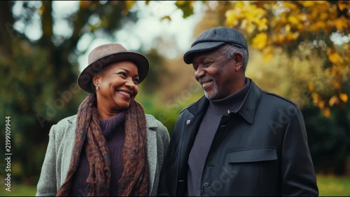 Joyful elderly couple enjoying a beautiful fall day together in the park. They share smiles and laughter amidst the colorful autumn leaves. Generative AI