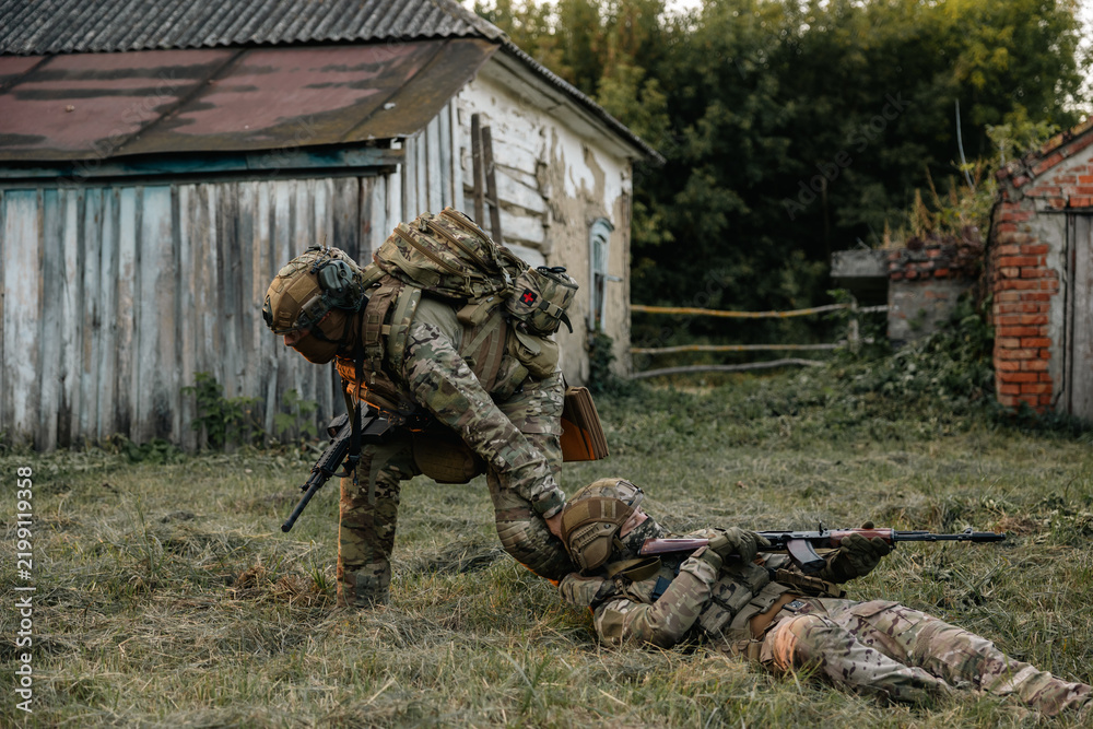 Obraz premium Modern warfare military squad in battle action rescue wounded soldier help and support concept