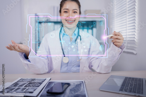 female doctor using a futuristic holographic medical interface and digital tablet in a modern clinic.