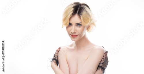 A young blonde girl with clean skin wearing black gloves. Beauty portrait of a woman on a white background in the studio.