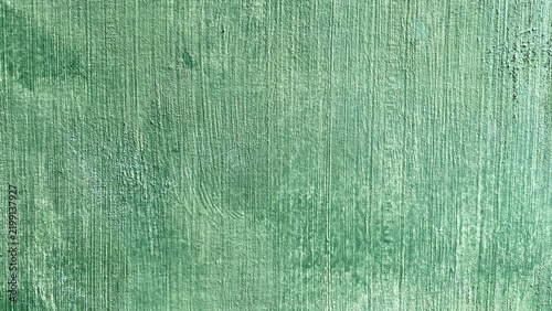 Rough green painted concrete wall texture with vertical brushstrokes