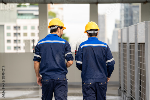 Engineer Industrial engineer worker construction helmet safety uniform inspection facility rooftop urban building teamwork professional male technician