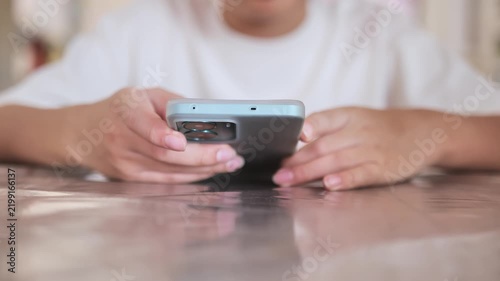 Young child using smartphone indoors looking at screen