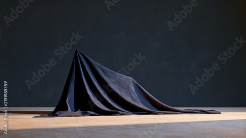 Black Fabric Draped over Hidden Object on Minimal Stage