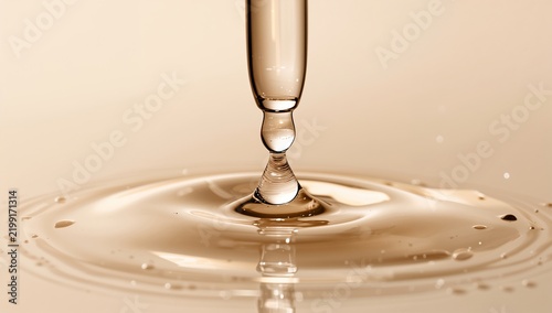 Water Droplet Falls to Surface Creating Ripples in Liquid