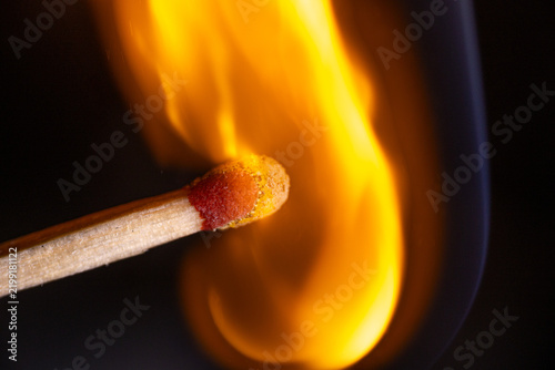 фотографія Burning wooden match with glowing red head and bright orange yellow flame agains
