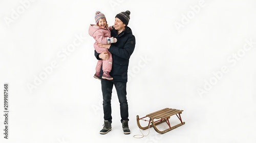 Father holding his laughing daughter in winter clothes with a wooden