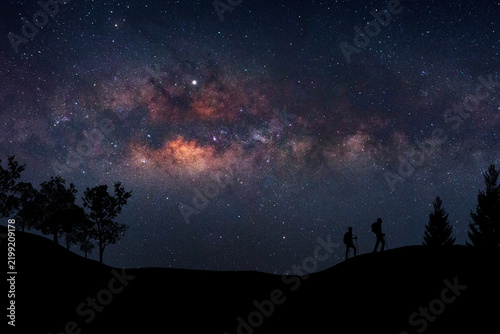 Landscape with Milky Way. Night sky with stars and silhouette of a standing happy man on the mountain, Success or winner, leader concept. High iso with Noise.
