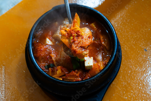 Spoonful of Thick Tender Pork Belly Lifted from Spicy Kimchi Stew