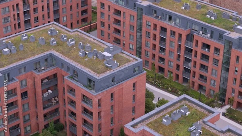 Modern sustainable architecture with green plant roofs in an urban residential neighborhood.