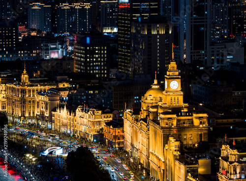 Photography Night view of the historic buildings illuminated along the Bund, glowing with golden lights above busy street traffic