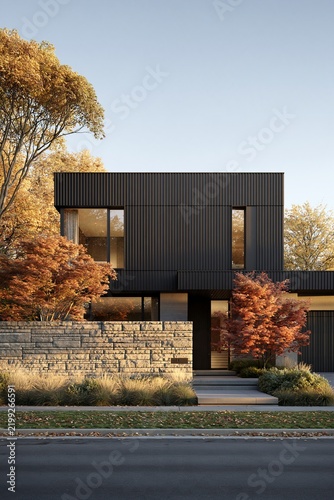 Modern luxury home exterior with dark metal facade and fall foliage trees