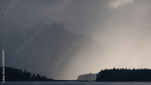 Breathtaking Alaska mountain glacier range view seen from outdoor deck of cruise ship liner sailing the Inside Passage transit with spectacular landscape scenery during sunset