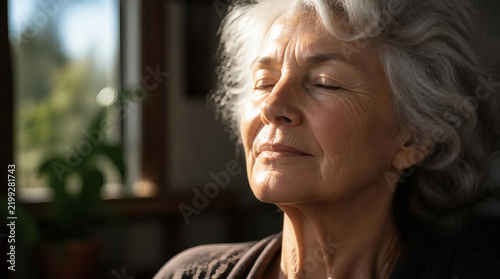 Elderly Woman Enjoying Warm Sunlight Near Window Serene and Peaceful Moment