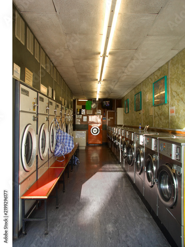 Принти на полотні Narrow laundromat aisle lined with washing machines