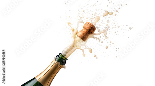 Close up of champagne bottle popping cork with explosion of bubbles