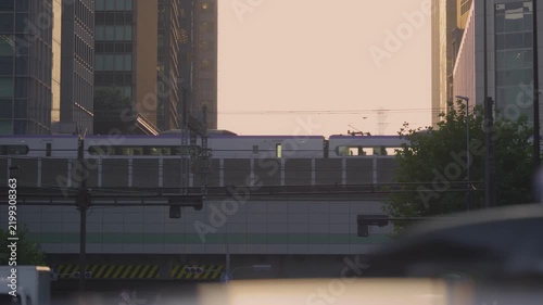 夕暮れにビルの間を走る電車