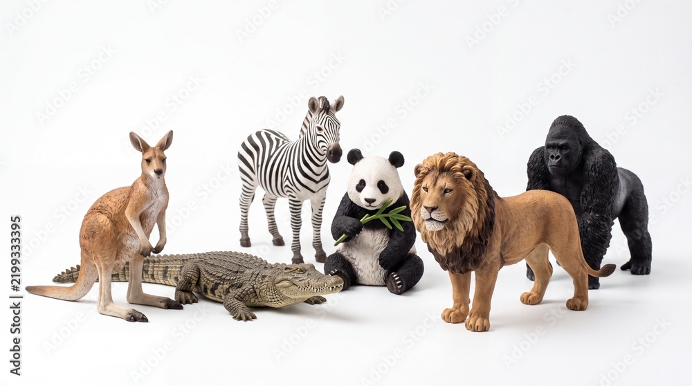 Fototapeta premium Various plastic toy zoo animals standing together in a group composition isolated on white background
