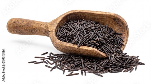 Healthy wild black rice grains inside rustic wooden kitchen scoop isolated on white background