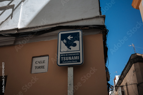 Tsunami evacuation route sign on Calle Torre in a city setting under clear blue sky