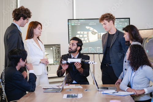 Diverse technology professionals collaborating around a humanoid robot prototype while discussing robotics, artificial intelligence, engineering, and innovation.