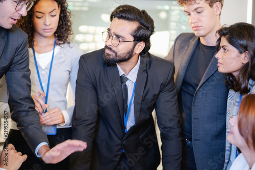 Diverse business professionals collaborating in a modern workplace, sharing ideas and discussing project strategy during a team meeting.
