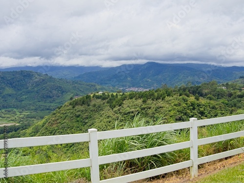 Canvas Print Scenic view of Orosi Valley mountains behind white fence at Mirador de Ujarrás