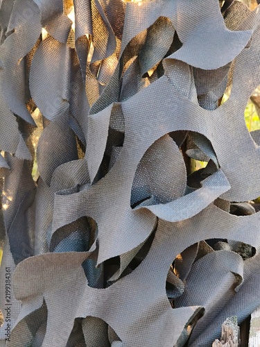 Canvastavla Close-up texture of dark camouflage netting fabric with cutouts.