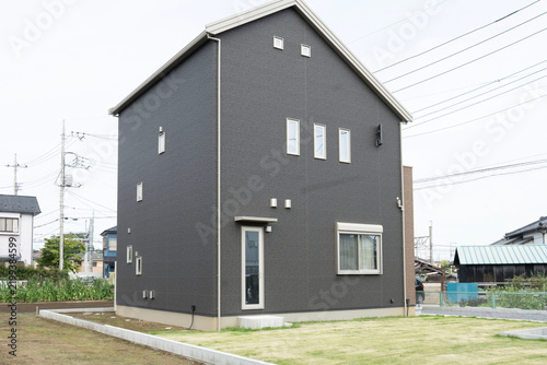 ダークグレーの落ち着いた外壁とすっきりした切妻屋根が魅力的な現代の戸建て住宅