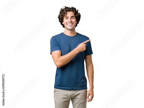 A cheerful young man with curly hair smiling and pointing to the side