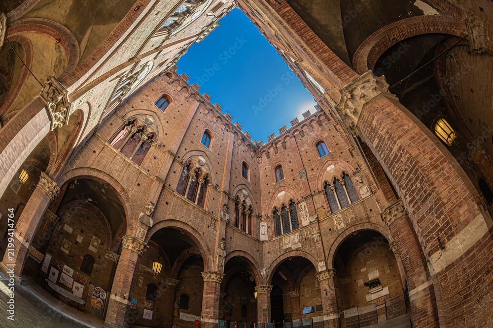 Fototapeta premium Siena, Tuscany, Italy – May 23, 2026: The inner courtyard of the Palazzo Pubblico (the city hall), with medieval Gothic architecture. Build in 1297 to house the government of the republic.