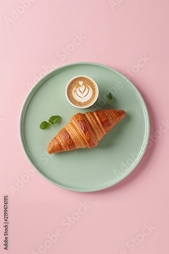 Fresh Croissant and Coffee on a Green Plate With Pink Background