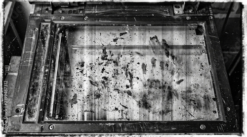 Dirty glass scanner bed of an office photocopier with dust and debris