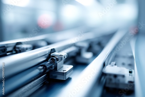 Automated industrial production line rail system. Blurred manufacturing factory background