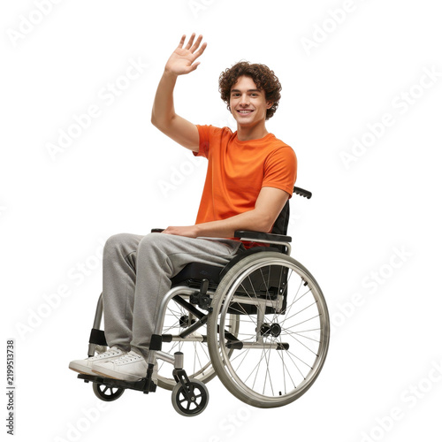 Young man using wheelchair waving hello with friendly smile isolated on white