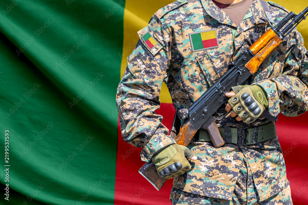 Obraz premium Benin flag with soldier holding assault rifle
