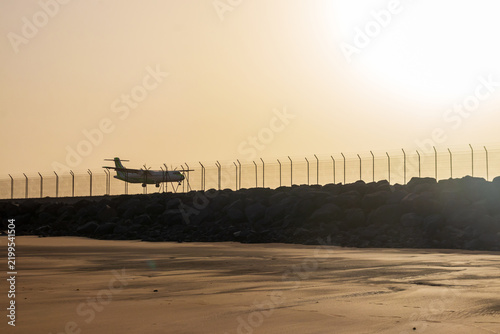 Passenger airplane landing at the airport runway over the sandy beach at Playa de Guacimeta in Lanzarote, Canary Islands, Spain