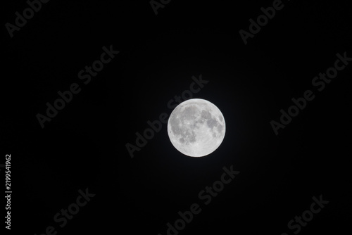 Astronomy photography of a glowing full moon phase in a dark midnight sky