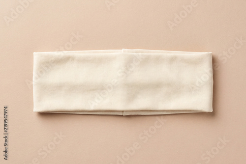 Blank beige ribbed cotton headband isolated on a warm neutral background