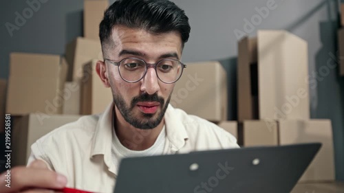 Young man with glasses focuses on tablet