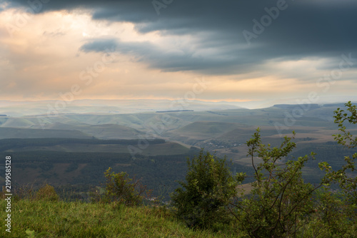 Layers of green mountains and hills in the haze during sunset. Panoramic View of Green hills and Meadow.